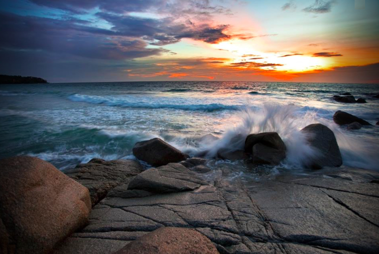 pic of sky at dawn and ocean splash against rocks